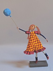 Art doll grasping string of balloon