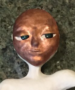 close up of art doll with face plate to guage eye placement