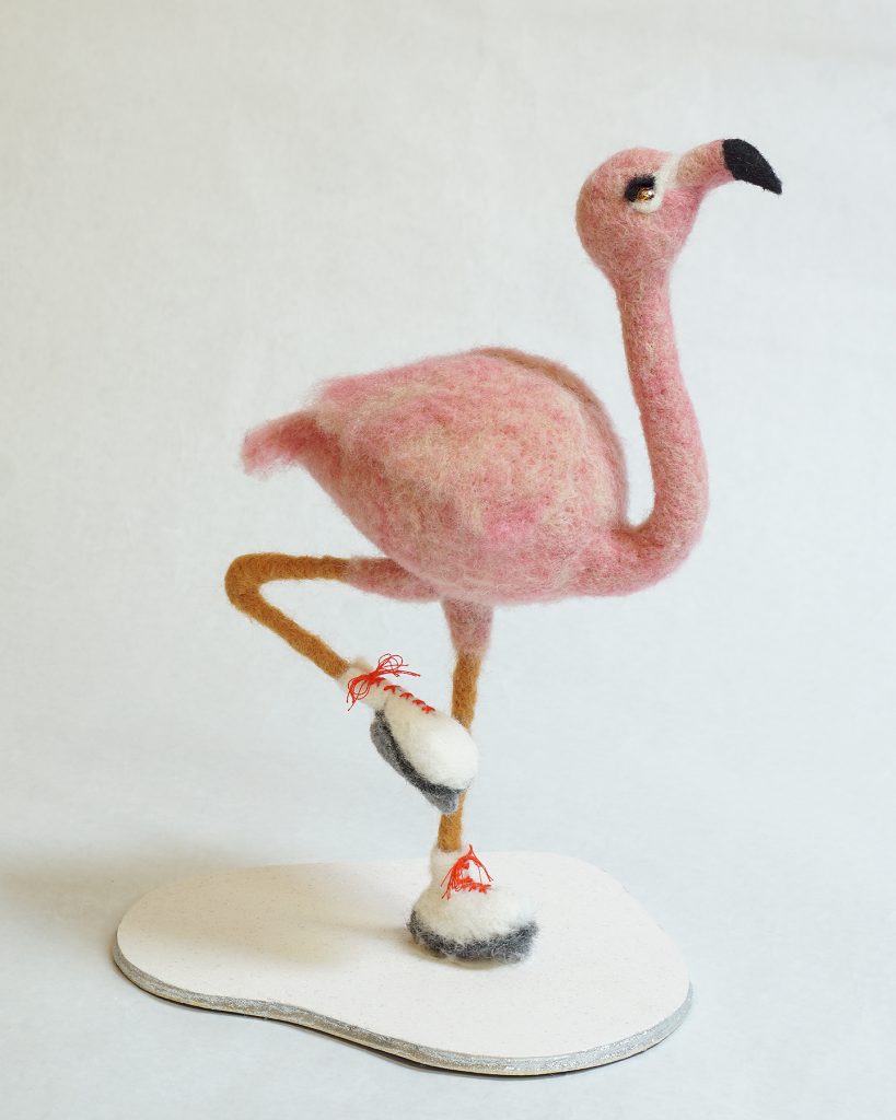 Anthropomorphic flamingo on ice skates. Needle felted wool over wire and batting armature