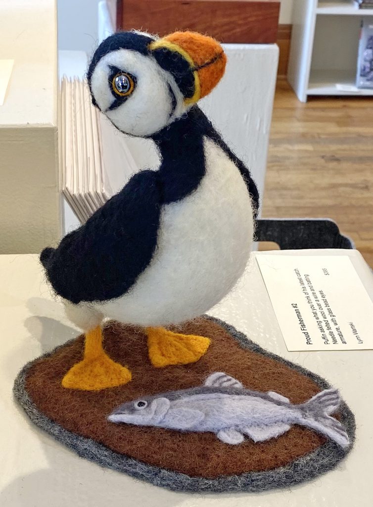 needle felted puffin sculpture with a fish