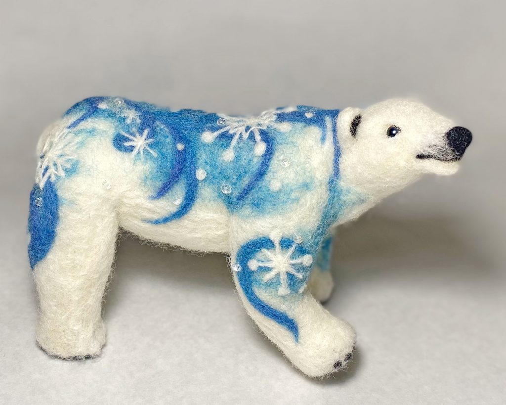 Polar bear anthropomorphic sculpture with snow motif. Needle felted sculpture