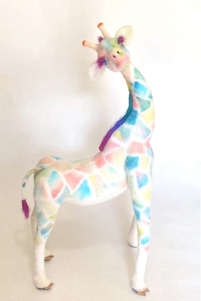 Peace is a "tye dye" giraffe sculpture. Needle felted wool over wire and quilit batting armature.