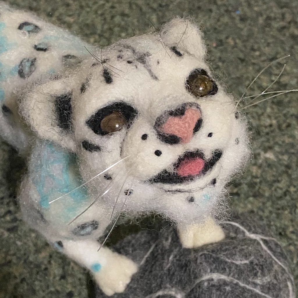 anthropomorphic snow leopard sculpture needle felted wool over wire and batting armature, with "snow" leopard patterning. made artist try more reverse felting