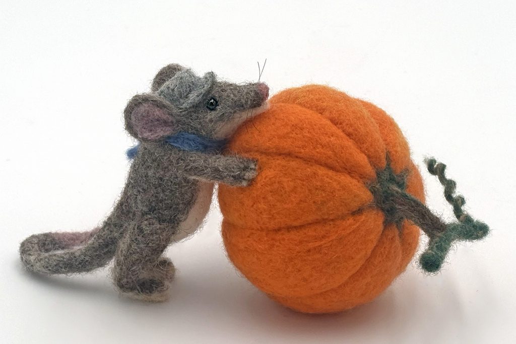 Harvest is an anthropomorphic mouse figure sculpture with a pumpkin. Needle felted wool
