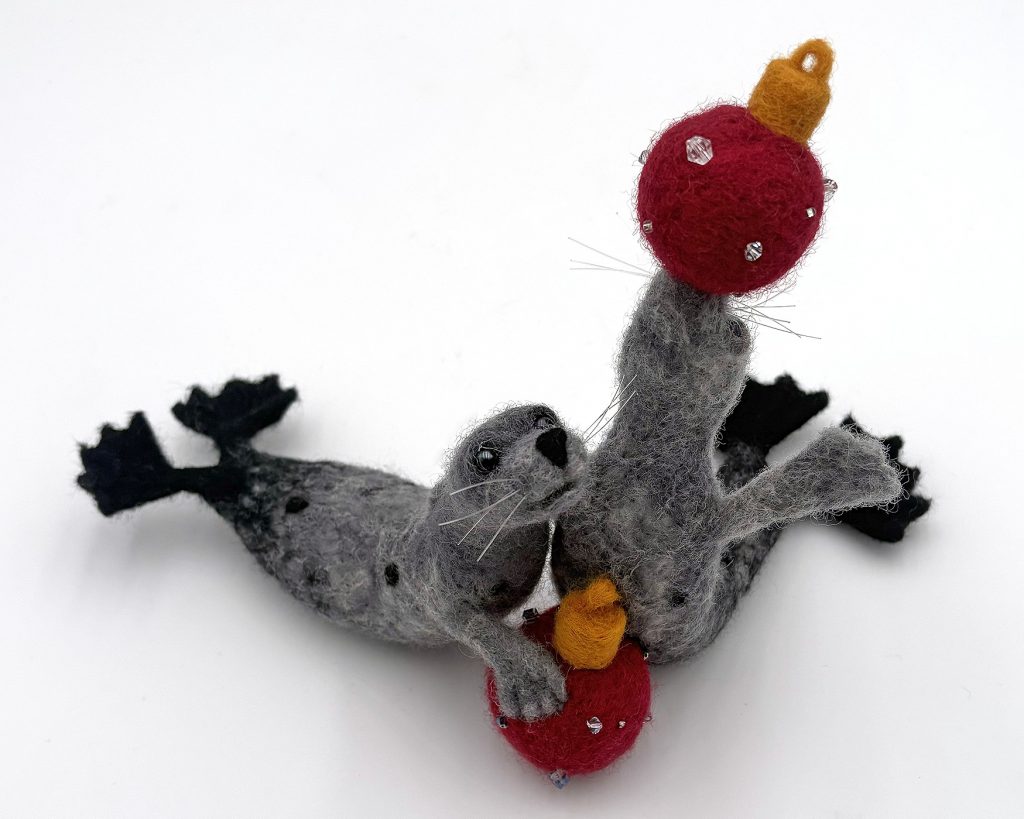 anthropomorphic holiday themed sculpture of seals with ornaments